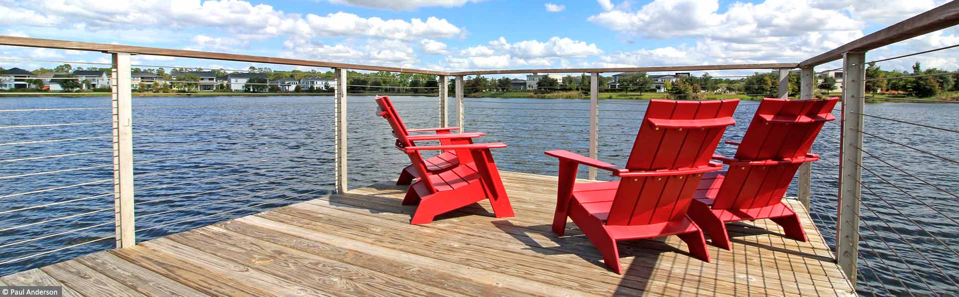 red chairs overlooking a lake in a pier